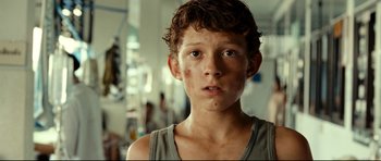 Movie still from “The Impossible” (2012), directed by J.A. Bayona – A young boy with a very dirty face looking at the camera; Close Up shot, Low angle