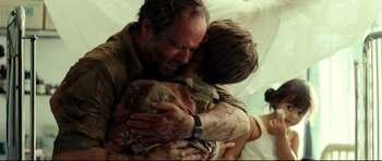 Movie still from “The Impossible” (2012), directed by J.A. Bayona – A man and a woman hugging each other; Close Up shot, Over the shoulder angle