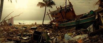 Movie still from “The Impossible” (2012), directed by J.A. Bayona – A beach with debris and a palm tree; Extreme Wide shot, Low angle