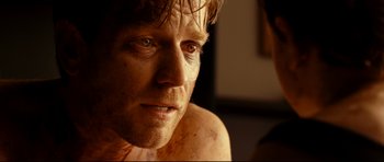 Movie still from “The Impossible” (2012), directed by J.A. Bayona – A man's face in a dark room; Close Up shot, Over the shoulder angle