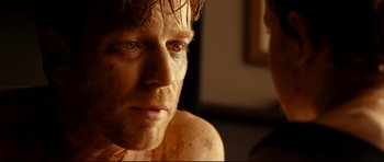 Movie still from “The Impossible” (2012), directed by J.A. Bayona – A man's face in a dark room; Close Up shot, Over the shoulder angle