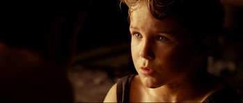 Movie still from “The Impossible” (2012), directed by J.A. Bayona – A young child's face in a dark room; Close Up shot, Over the shoulder angle