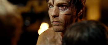 Movie still from “The Impossible” (2012), directed by J.A. Bayona – A person with his eyes closed; Close Up shot, Over the shoulder angle