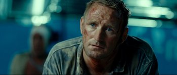 Movie still from “The Impossible” (2012), directed by J.A. Bayona – A person wearing a shirt and looking at the camera; Close Up shot, Over the shoulder angle