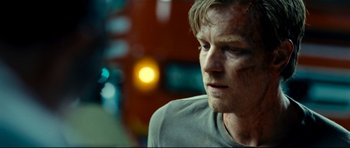 Movie still from “The Impossible” (2012), directed by J.A. Bayona – A person wearing a gray t - shirt; Close Up shot, Over the shoulder angle