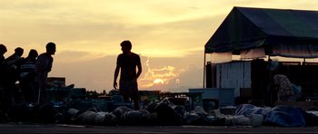 Movie still from “The Impossible” (2012), directed by J.A. Bayona – A man standing on top of a pile of garbage; Wide shot, Low angle