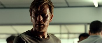 Movie still from “The Impossible” (2012), directed by J.A. Bayona – A person wearing a shirt with blood all over his face; Close Up shot, Over the shoulder angle