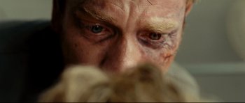 Movie still from “The Impossible” (2012), directed by J.A. Bayona – A man's face with bruises on his face; Extreme Close Up shot, Overhead angle