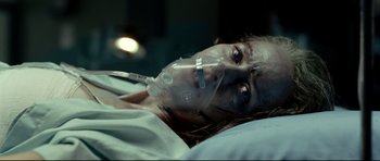 Movie still from “The Impossible” (2012), directed by J.A. Bayona – A woman laying in a hospital bed with a mask over her face; Close Up shot, Overhead angle