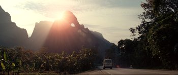 Movie still from “The Impossible” (2012), directed by J.A. Bayona – A van driving down a road near a mountain; Extreme Wide shot, Low angle
