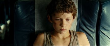 Movie still from “The Impossible” (2012), directed by J.A. Bayona – A young boy is sitting on a couch; Close Up shot, High angle