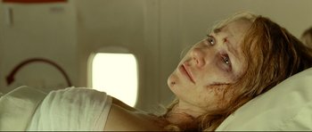 Movie still from “The Impossible” (2012), directed by J.A. Bayona – A person laying on a bed with blood all over her face; Close Up shot, Overhead angle