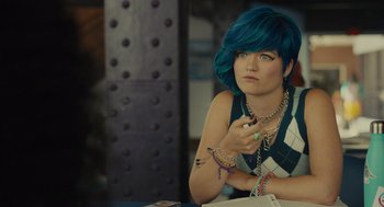 A woman with blue hair sitting at a table