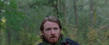 Movie still from “Apex” (2021), directed by Edward Drake – A person with a beard; Close Up shot, Over the shoulder angle