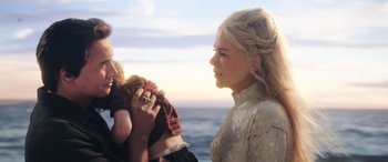 Movie still from “Aquaman” (2018), directed by James Wan – A woman holding a baby while standing on a beach; Close Up shot, Over the shoulder angle