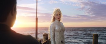 Movie still from “Aquaman” (2018), directed by James Wan – A woman standing on a pier in front of the ocean; Medium shot, Over the shoulder angle