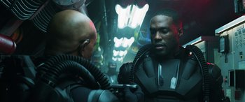 Movie still from “Aquaman” (2018), directed by James Wan – Two men are talking to each other in a room; Medium shot, Over the shoulder angle