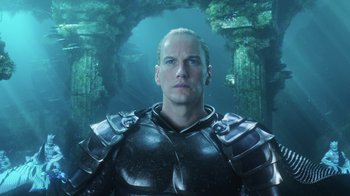 Movie still from “Aquaman” (2018), directed by James Wan – A man in armor standing in front of an underwater forest; Close Up shot, Low angle