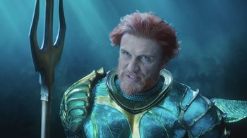 Movie still from “Aquaman” (2018), directed by James Wan – An image of a man with a red beard in a suit of aquaman; Close Up shot, High angle