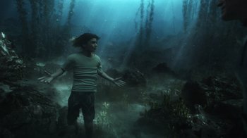 Movie still from “Aquaman” (2018), directed by James Wan – A man standing in the middle of a underwater forest; Wide shot, High angle