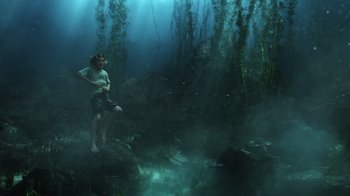 Movie still from “Aquaman” (2018), directed by James Wan – A man standing in the middle of a body of water; Wide shot, Low angle