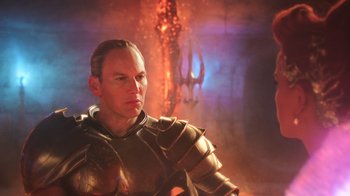 Movie still from “Aquaman” (2018), directed by James Wan – A man wearing a suit of armor in front of a fire background; Medium shot, Over the shoulder angle