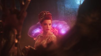 Movie still from “Aquaman” (2018), directed by James Wan – A woman in a dress and a crown with lights around her head; Medium shot, Over the shoulder angle