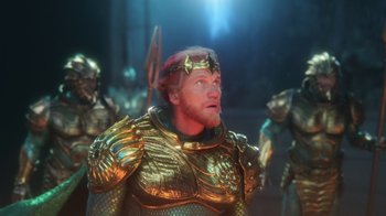 Movie still from “Aquaman” (2018), directed by James Wan – A group of people dressed in gold armor and helmets; Medium shot, Over the shoulder angle