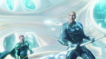 Movie still from “Aquaman” (2018), directed by James Wan – A man in a blue suit is holding a sword; Wide shot, Low angle