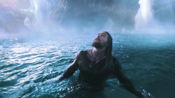 Movie still from “Aquaman” (2018), directed by James Wan – A man with long hair is in the water; Medium shot, Low angle