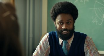 A man with a beard wearing a vest and a tie