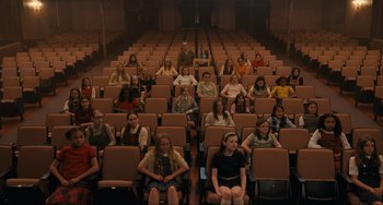 A group of people sitting in rows of seats in an auditorium