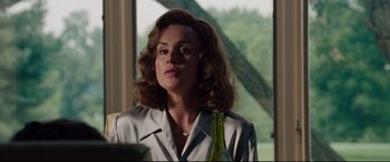 Movie still from “The Insider” (1999), directed by Michael Mann – A woman in a white shirt holding a wine bottle; Close Up shot, Over the shoulder angle