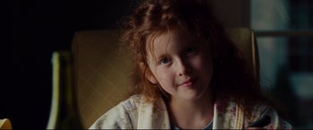 Movie still from “The Insider” (1999), directed by Michael Mann – A young girl with red curly hair is posing for a picture; Close Up shot, Over the shoulder angle