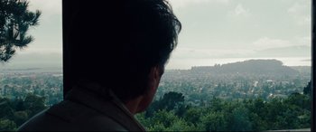 Movie still from “The Insider” (1999), directed by Michael Mann – A man looking out over a city from a hill; Close Up shot, High angle