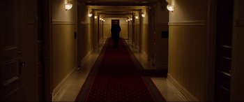 Movie still from “The Insider” (1999), directed by Michael Mann – A person walking down a long hallway in a hotel; Wide shot, High angle