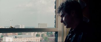 Movie still from “The Insider” (1999), directed by Michael Mann – A man looking out of a window at a city skyline; Close Up shot, Over the shoulder angle