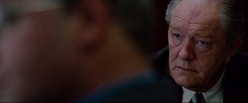 Movie still from “The Insider” (1999), directed by Michael Mann – An older man is looking into the distance; Close Up shot, Over the shoulder angle