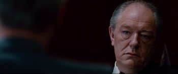 Movie still from “The Insider” (1999), directed by Michael Mann – An older man in a white shirt is looking at the camera; Close Up shot, Low angle