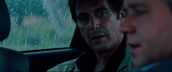 Movie still from “The Insider” (1999), directed by Michael Mann – A person sitting in a car on a rainy day; Close Up shot, Over the shoulder angle