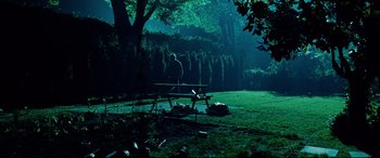 Movie still from “The Insider” (1999), directed by Michael Mann – A man sitting at a picnic table at night; Wide shot, Over the shoulder angle