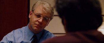 Movie still from “The Insider” (1999), directed by Michael Mann – A person wearing glasses and a tie; Close Up shot, Over the shoulder angle