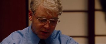 Movie still from “The Insider” (1999), directed by Michael Mann – An older man wearing glasses and a blue shirt; Close Up shot, Low angle