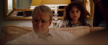 Movie still from “The Insider” (1999), directed by Michael Mann – A man and a little girl sitting on a couch; Close Up shot, Over the shoulder angle