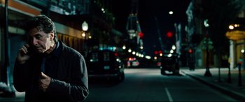 Movie still from “The Insider” (1999), directed by Michael Mann – A man standing on the side of a road at night; Medium shot, Over the shoulder angle