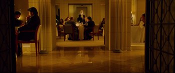 Movie still from “The Insider” (1999), directed by Michael Mann – A group of people sitting around a table at a restaurant; Wide shot, High angle