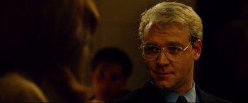 Movie still from “The Insider” (1999), directed by Michael Mann – A person wearing glasses and a suit; Close Up shot, Over the shoulder angle
