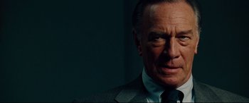 Movie still from “The Insider” (1999), directed by Michael Mann – An older man wearing a suit and tie; Close Up shot, Over the shoulder angle