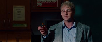 Movie still from “The Insider” (1999), directed by Michael Mann – A man holding a lit candle in his hand; Close Up shot, Over the shoulder angle