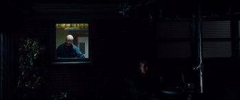 Movie still from “The Insider” (1999), directed by Michael Mann – A man sitting in front of a window at night; Wide shot, Over the shoulder angle